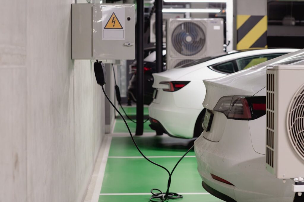 pexels-photo-28851165 Electric vehicles charging at an indoor station in a modern underground garage.