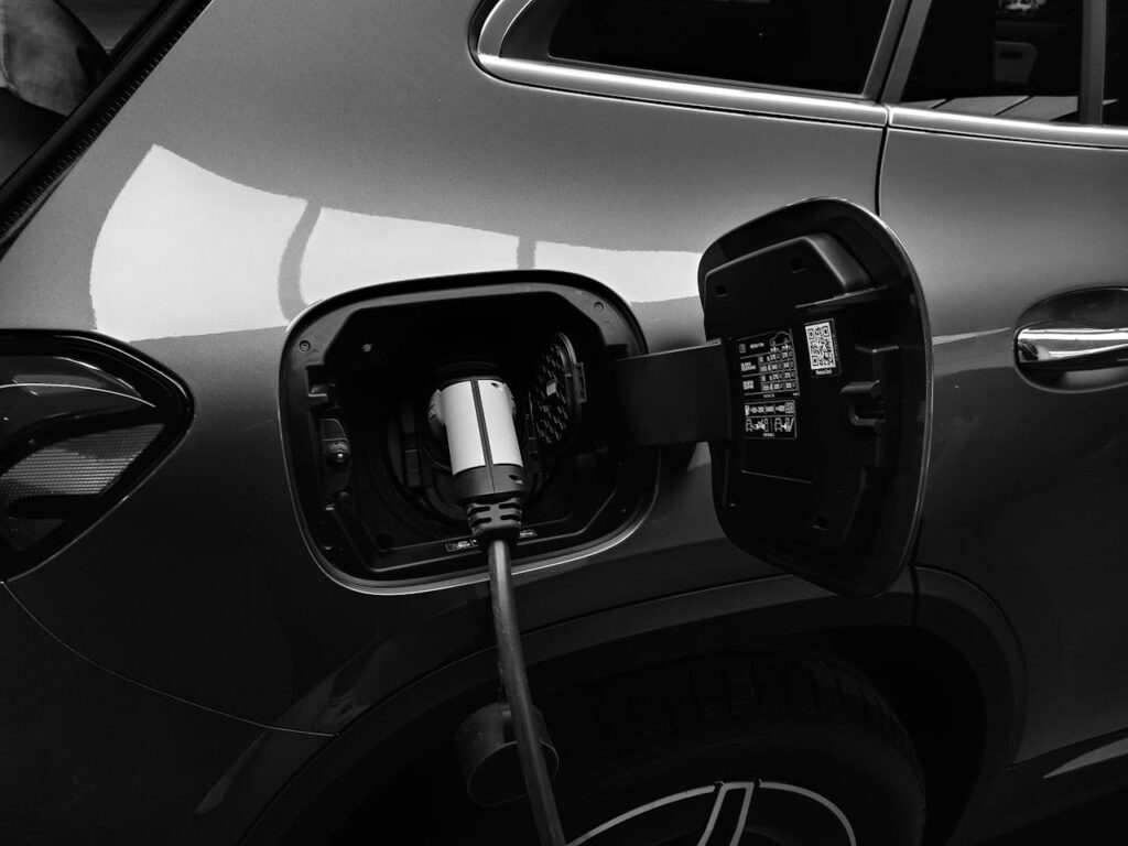 pexels-photo-8349487 Close-up black and white image of an electric vehicle charging at a station.